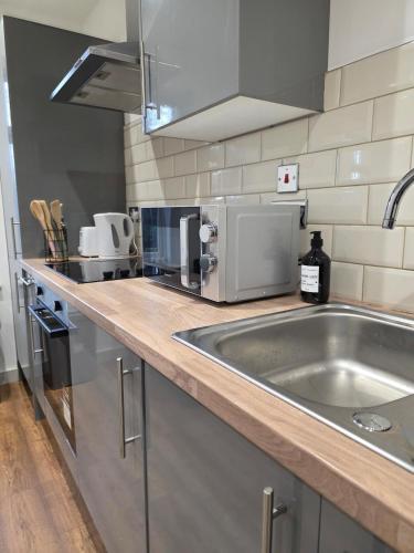 a kitchen counter with a sink and a microwave at Central Kidderminster Studio Flat 4 in Kidderminster