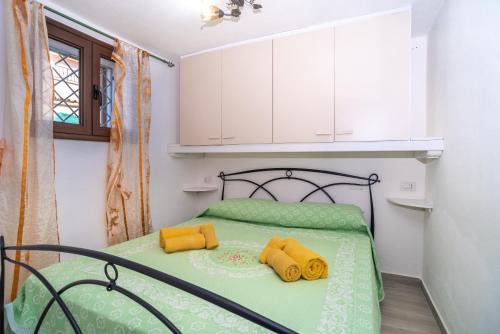 une chambre avec un lit avec des oreillers jaunes dessus dans l'établissement Casa Pietro, à San Teodoro