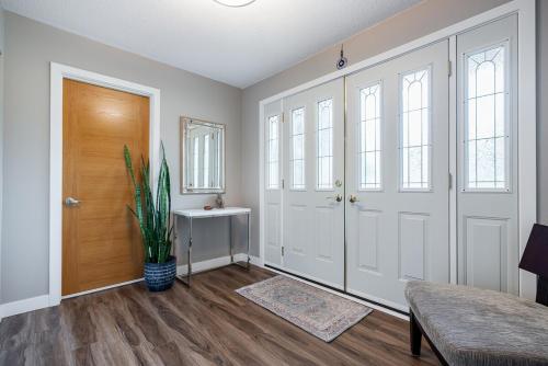 un corridoio con porte bianche e una pianta in vaso di Serene Nature Retreat a North Vancouver