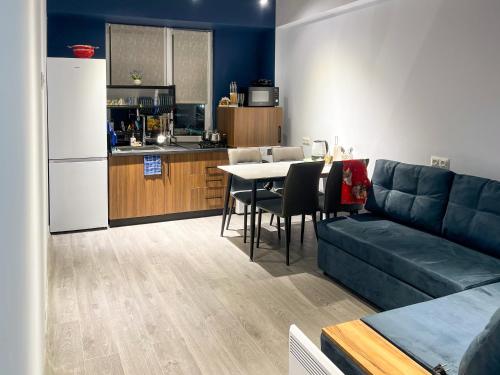 een woonkamer met een bank en een tafel en een keuken bij Bakuriani premium comfort in Bakuriani