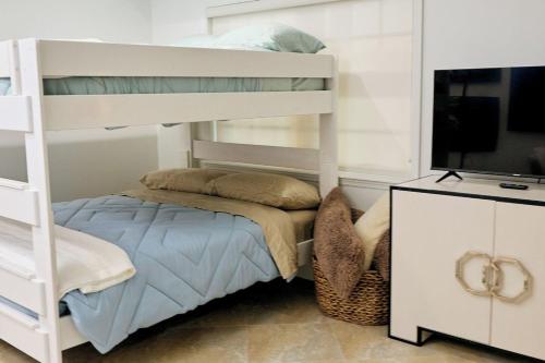 1 dormitorio con litera y TV en Escape to Paradise In West End Old Bahama Bay, en West End