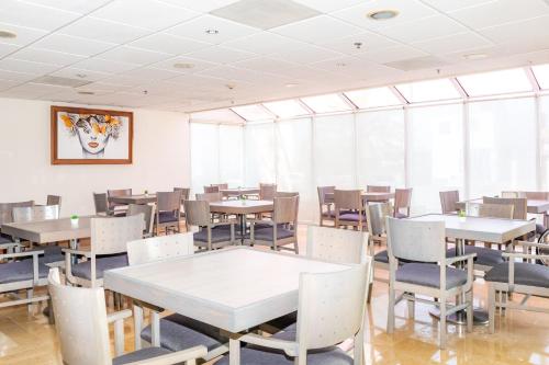 a dining room with tables and chairs and windows at Hotel Galerías Express in Tepatitlán de Morelos