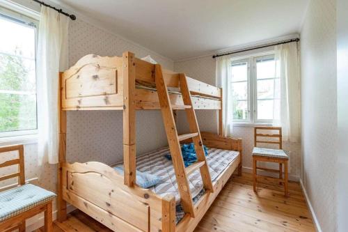 a bedroom with two bunk beds and two chairs at VGO822-Fjaeras-Grimmeredsvaegen-35 in Ubbhult