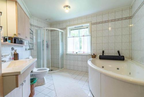 a bathroom with a tub and a toilet and a sink at VGO822-Fjaeras-Grimmeredsvaegen-35 in Ubbhult
