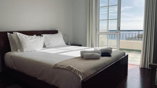 ein Schlafzimmer mit einem großen Bett mit einem großen Fenster in der Unterkunft Maribel's Place in Funchal