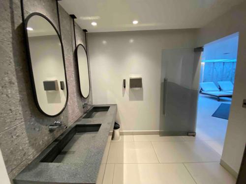 キトにあるSuite Piso 17 - Increible Vista - Agua filtrada ilimitadaの洗面台と鏡とソファのあるバスルーム