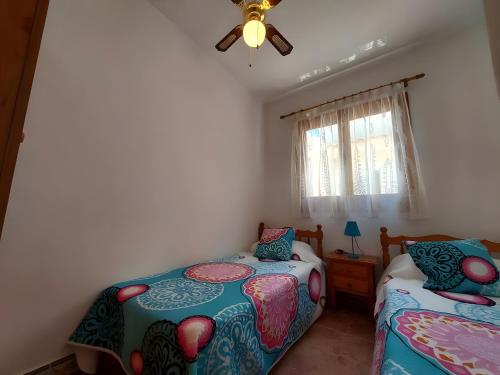 een slaapkamer met twee bedden en een plafondventilator bij Manuel 217 en Gran Alacant in Gran Alacant