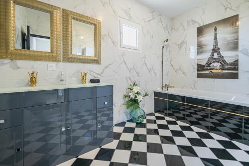 ein Badezimmer mit schwarz-weiß kariertem Boden in der Unterkunft Villa Caudy Kaz - calme et confort - Wiskeys in Sainte-Marie