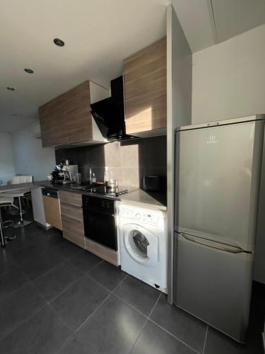 eine Küche mit einer Waschmaschine und einem Geschirrspüler in der Unterkunft Appartement Vue mer La Croix Valmer in La Croix-Valmer