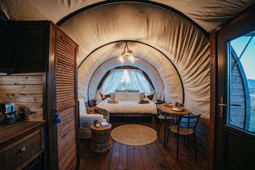 a room with a bed and a table in a tent at Sunrise Hills Country in Vălenii de Munte