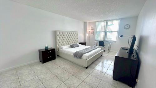 ein Schlafzimmer mit einem Bett und einem Fernseher darin in der Unterkunft Sea Air Towers - Oceanfront Condo w Pool & Gym in Beverley Beach