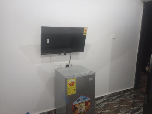 a flat screen tv hanging on a white wall at Eastern Comfort Hotel in Koforidua