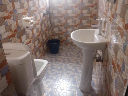 a bathroom with a toilet and a sink at Eastern Comfort Hotel in Koforidua