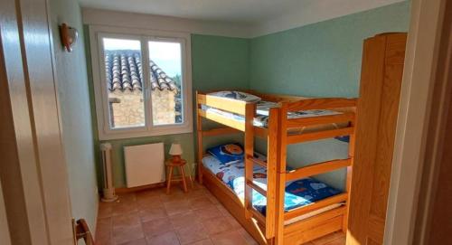 サント・クロワ・デュ・ヴェルドンにあるL'amourié, Rdc, Gîte 4 Personnesの二段ベッドが2つと窓のある部屋