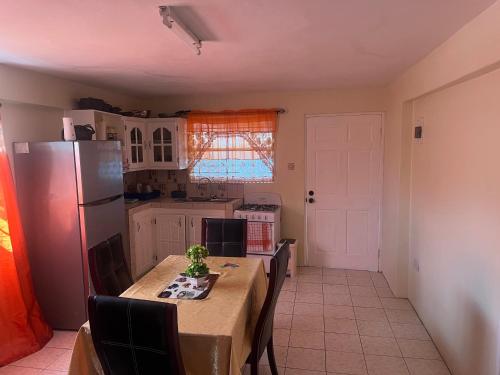una cucina con tavolo con sedie e frigorifero di Mountain View Apartments a Gros Islet