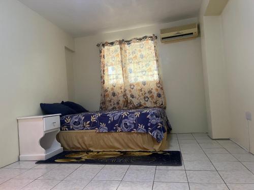 een kleine kamer met een bed en een raam bij Mountain View Apartments in Gros Islet