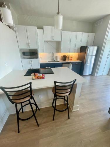 a kitchen with a white counter and two chairs at Cozy, Charming, and Chic Stay in Dallas