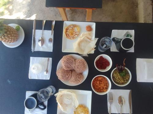 a table with plates of food and bowls of food at Stargate Villa in Talalla