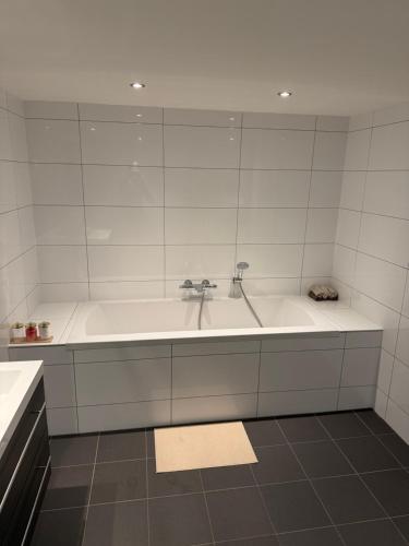 une salle de bain blanche avec une baignoire et un lavabo dans l'établissement Woonhuis 170m2 Rotterdam Centrum, à Rotterdam