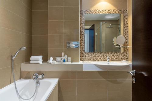 a bathroom with a tub and a sink and a mirror at Radisson Blu Hotel, Addis Ababa in Addis Ababa