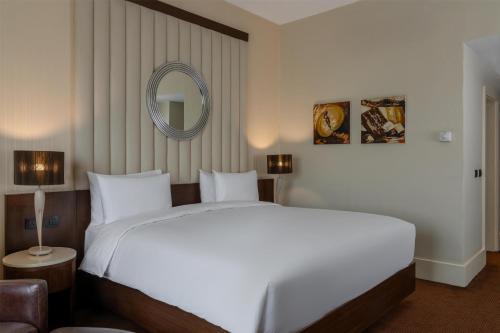 a bedroom with a large white bed and a mirror at Radisson Blu Hotel, Addis Ababa in Addis Ababa