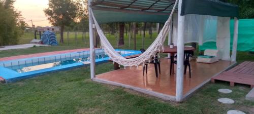a hammock in a gazebo next to a pool at El Nido in Sauce Viejo