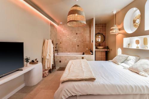 a bedroom with a large bed and a bath tub at Suite Marrakech avec jacuzzi privatif Love Room romantique proche Toulouse in Auterive