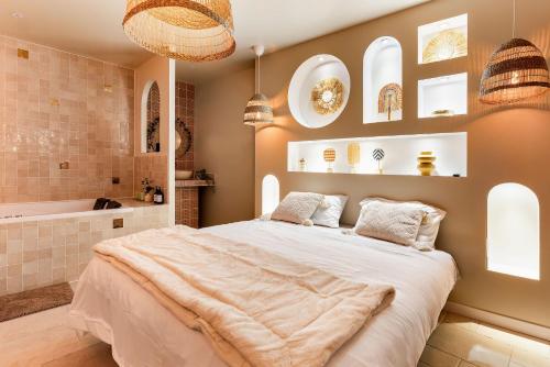 a bedroom with a large bed and a bath tub at Suite Marrakech avec jacuzzi privatif Love Room romantique proche Toulouse in Auterive