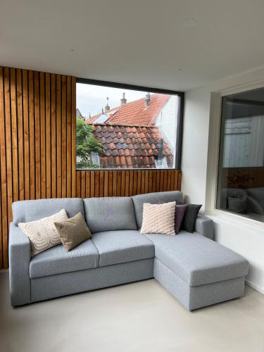 a living room with a couch and a window at Characteristic Dutch home in historic center Gouda in Gouda