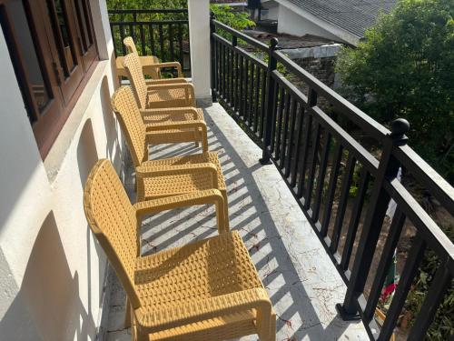 three wicker chairs sitting on a balcony at Sebastian Family Villa in Negombo