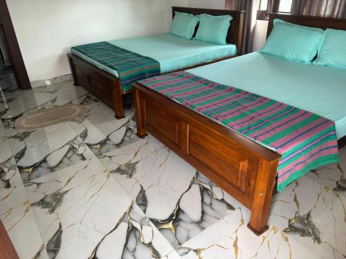 two beds sitting next to each other in a room at Sebastian Family Villa in Negombo