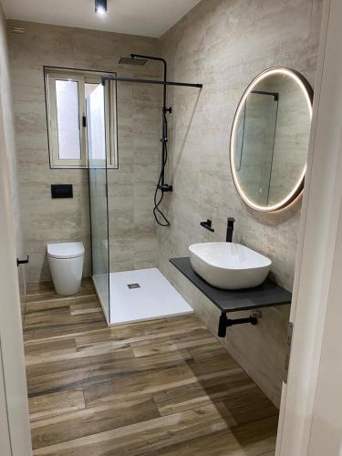 a bathroom with a sink and a mirror at Wedgewood - The XL Suite in Sliema