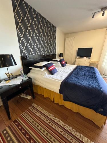 a bedroom with a large bed and a desk at Le studio Chez Marilé in Bry-sur-Marne