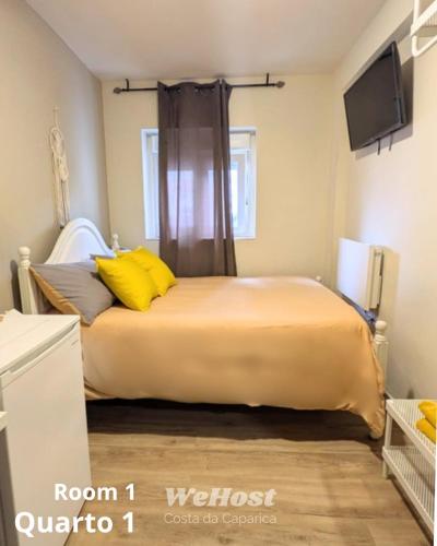 a bedroom with a large bed with yellow pillows at We Host Costa da Caparica in Costa da Caparica