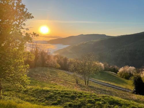 a sunset over a field with the sun in the distance at Total Peace and quiet on the top of the mountain, in Prats-de-Mollo-la-Preste