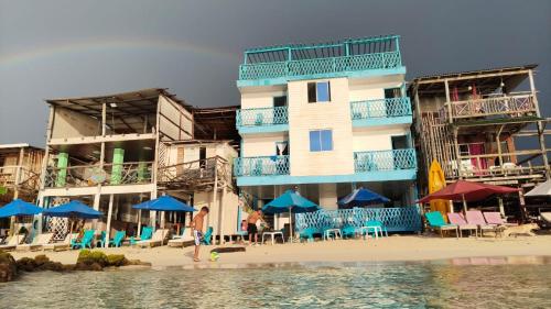 a building on the beach with chairs and umbrellas at Renacer ancestral Barú in Playa Blanca