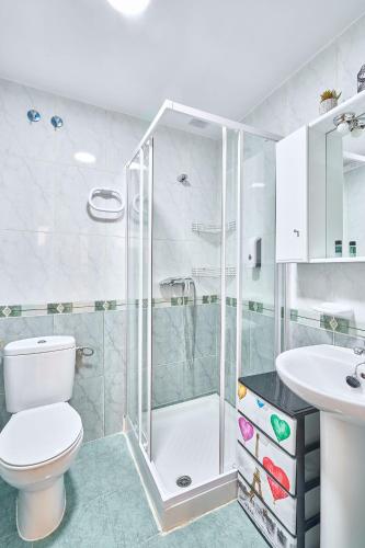 a bathroom with a shower and a toilet and a sink at San Justo Suites in Salamanca