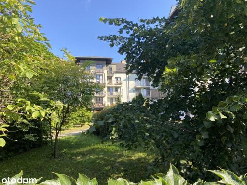 un edificio in mezzo a un cortile con alberi di Oliwa Business & Relax a Danzica