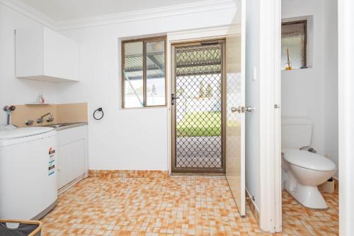een badkamer met een toilet, een wastafel en een deur bij Jurien Haven in Jurien Bay