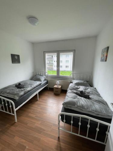ein Schlafzimmer mit zwei Betten und einem Fenster in der Unterkunft StayBaran XL - 7 Betten I WLAN I Parkplatz I Küche in Essen
