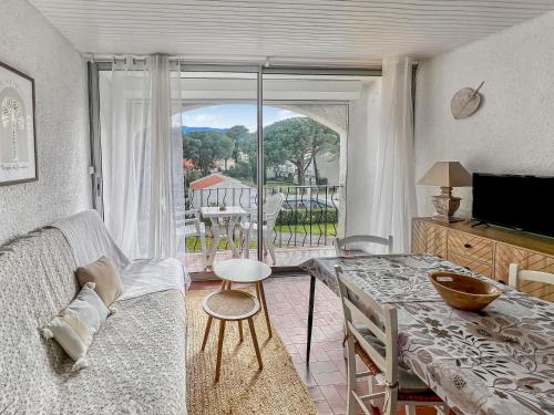 アルジェレス・シュル・メールにあるIdyllique ! Terrasse vue jardin et montagne, parking, local à vélos, à 2 pas de la plage et piscine de mai à septembre !のリビングルーム(ソファ、テーブル付)、バルコニーが備わります。