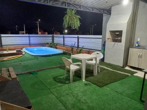 a patio with a table and chairs and a pool at Casa com piscina aquecida e área de festas no litoral in Ilhota