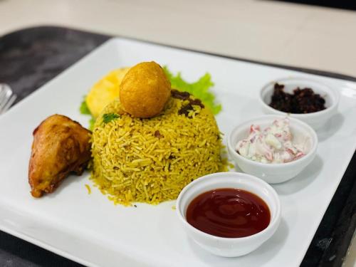 a plate of food with rice and other foods at Sinharaja Eliphinity Hotel and Restaurant in Nikawatawana