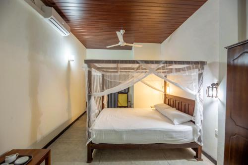 1 dormitorio con cama con dosel y techo en Merenza, en Unawatuna