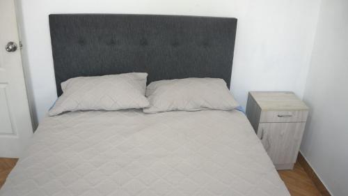 ワヌコにあるDepartamento excelente ubicaciónのベッド1台(枕2つ付)、ナイトスタンド