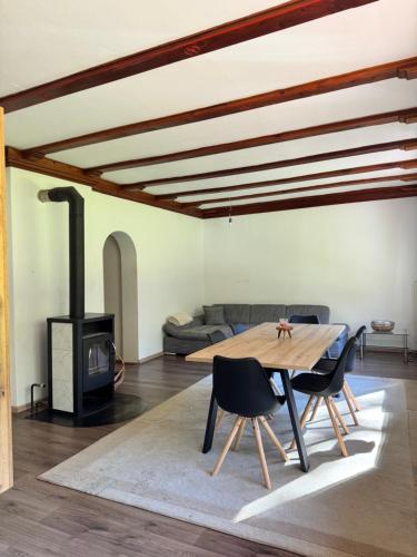 a living room with a wooden table and a fireplace at Cozy Mountain Stay near Kranjska Gora in Gozd Martuljek