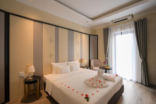 Un dormitorio con una cama blanca grande y una ventana en San Hotel & Pool, en Hanói