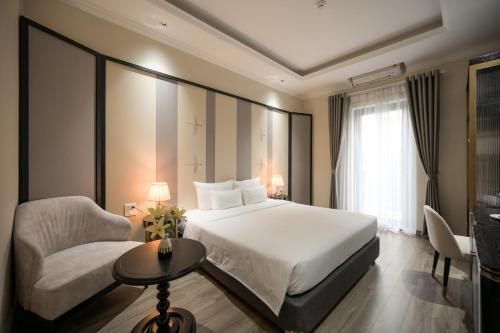 una habitación de hotel con una cama y una silla en San Hotel & Pool, en Hanói