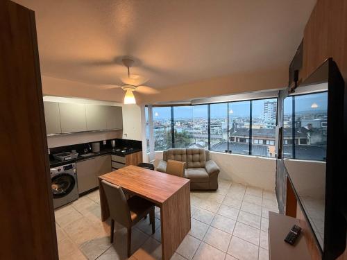 a living room with a table and a view of a city at Entre o Mar e o Centro - A melhor Localização in Torres