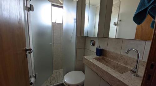 a bathroom with a toilet and a sink and a mirror at Entre o Mar e o Centro - A melhor Localização in Torres